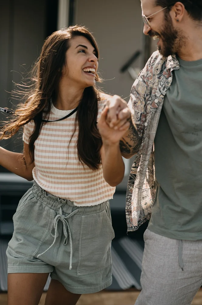 happy facial expression photo — A happy couple walks hand in hand, laughing and enjoying each other's company ou
