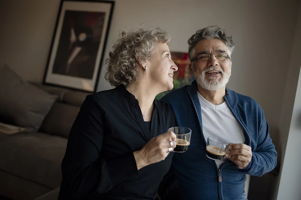 happy facial expression photo — Couple enjoying coffee together in their cozy living room