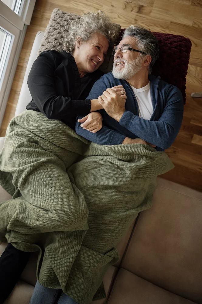 happy facial expression photo — Couple enjoys cozy time together under blankets