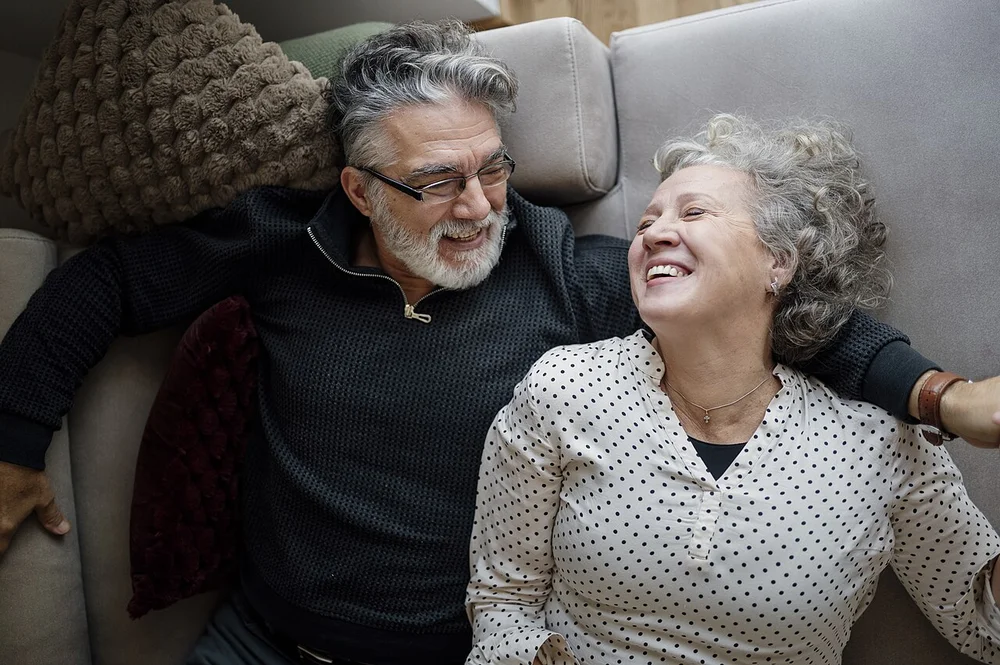 happy facial expression photo — Couple enjoys time together at home while relaxing on the sofa