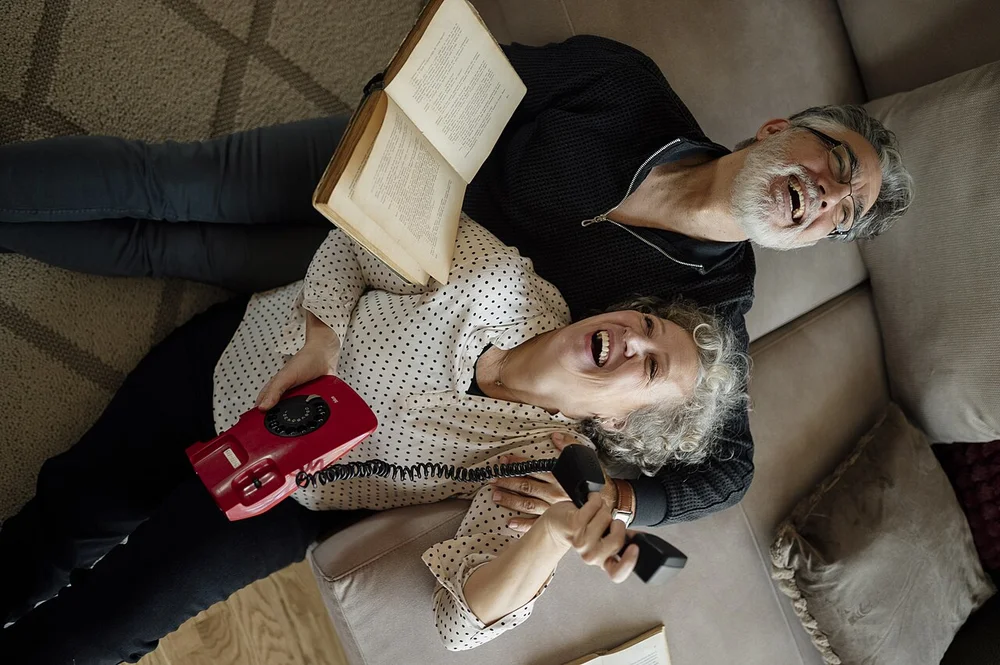 happy facial expression photo — Couple enjoys time together laughing and talking on the phone