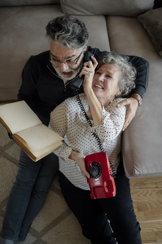 happy facial expression photo — Couple enjoys time together on the couch while talking on the phone