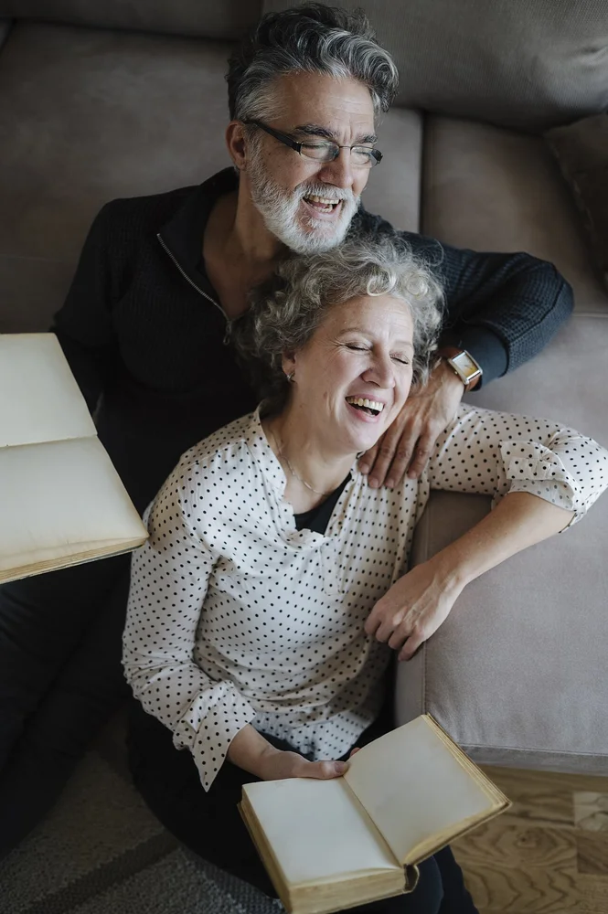happy facial expression photo — Couple shares laughter while sitting on a couch