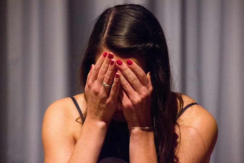 sad facial expression photo — Sad girl with head in hands